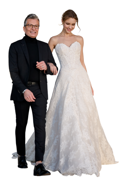 Randy Fenoli next to a bride in a wedding dress designed by him